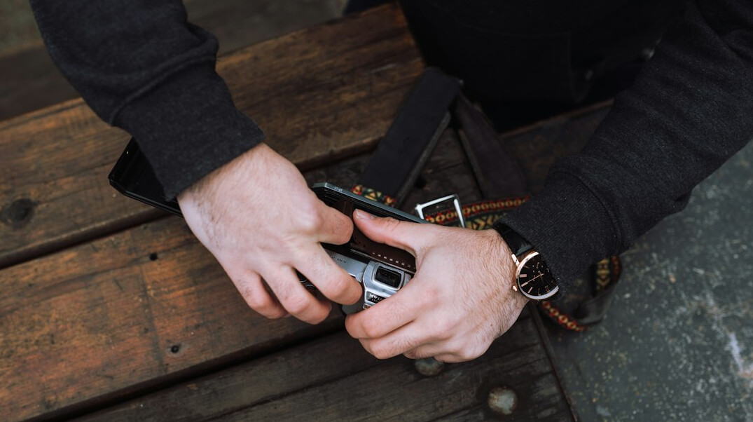 Close-up of hands adjusting an old film camera